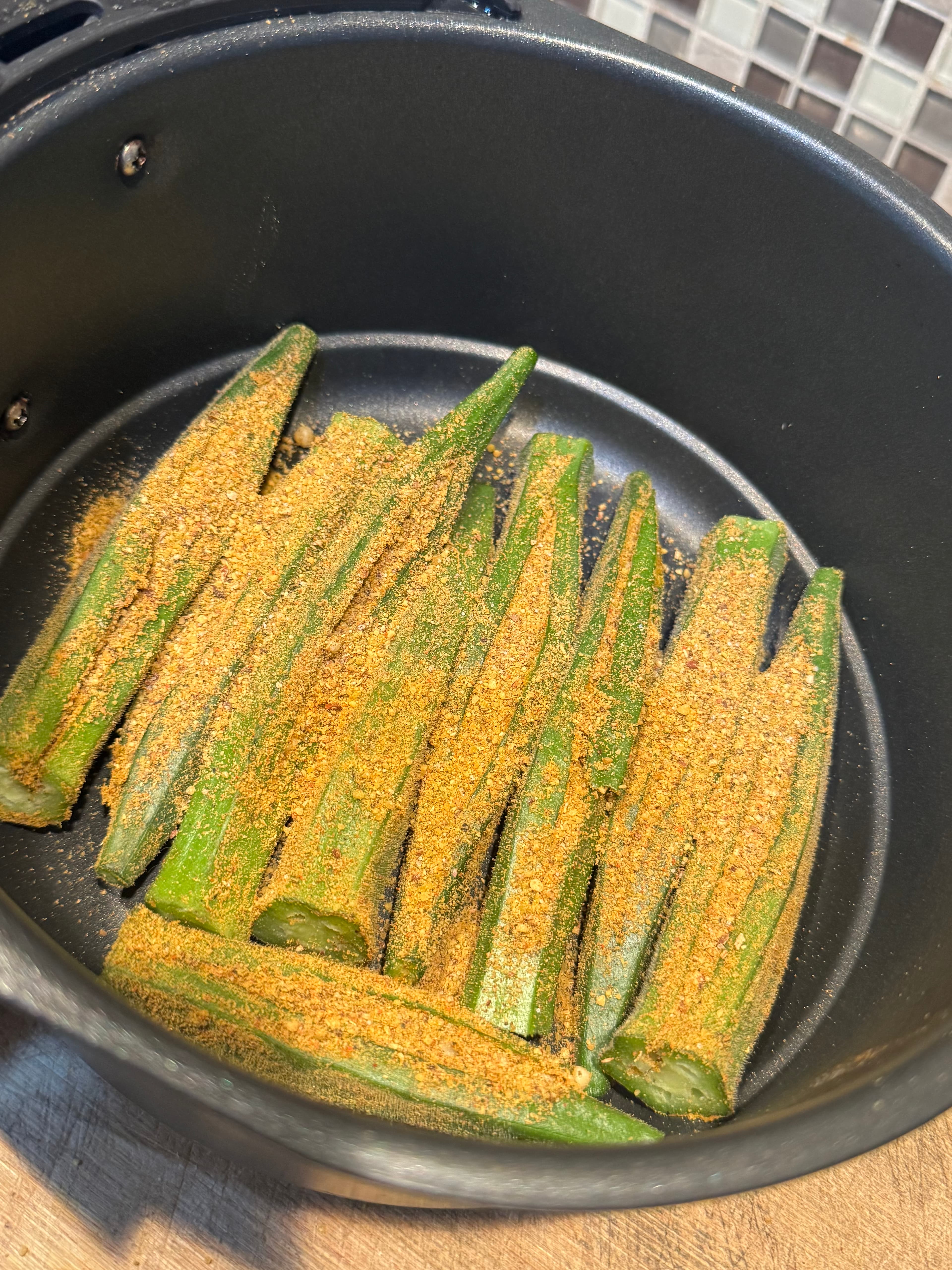 Seasoned stuffed okra in the air-fryer basket.